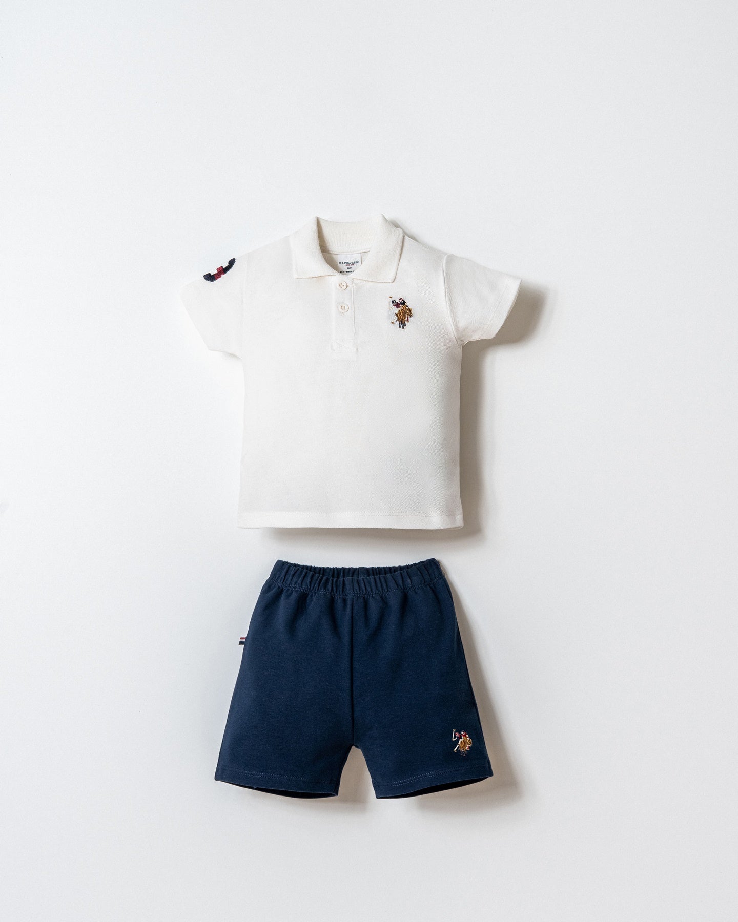 Set 2 Piese Băiețel Tricou Polo Alb Și Pantaloni Scurți Bleumarin Cu Logo Colorat